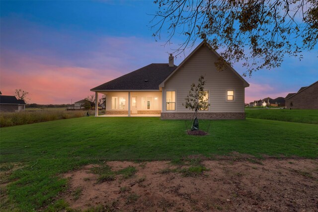 back house at dusk with a yard