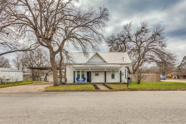 view of front facade with a carport, a porch, and a front lawn