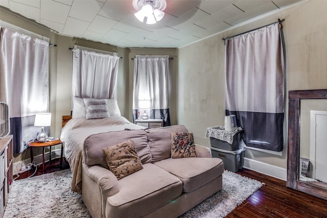 bedroom with dark hardwood / wood-style flooring and crown molding