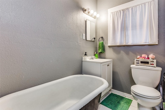 bathroom featuring vanity, a tub to relax in, tile patterned flooring, and toilet