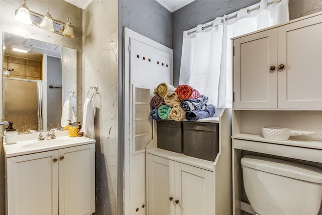 bathroom featuring vanity, an enclosed shower, and toilet