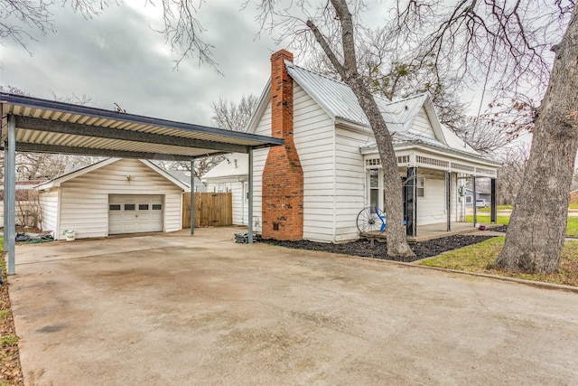 view of home's exterior with a garage, an outdoor structure, and a carport