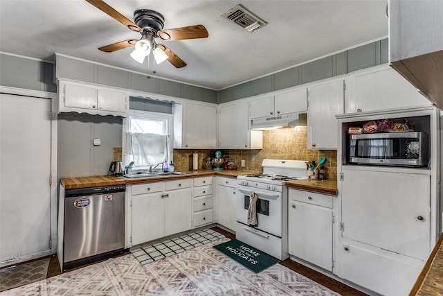 kitchen with butcher block counters, sink, white cabinetry, appliances with stainless steel finishes, and decorative backsplash