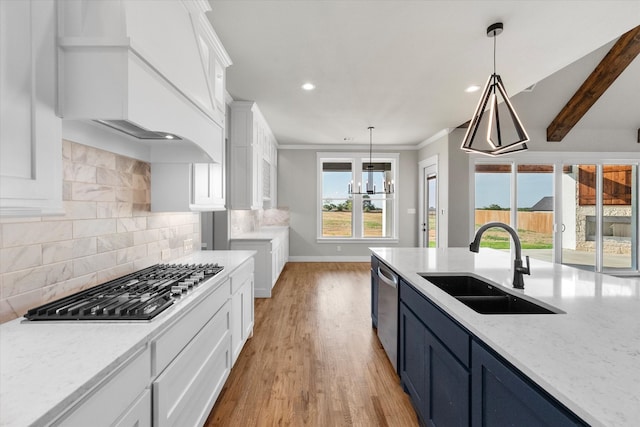 kitchen with sink, light hardwood / wood-style floors, tasteful backsplash, crown molding, and pendant lighting