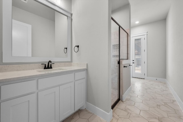 bathroom with an enclosed shower, vanity, and tile patterned floors