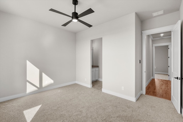 unfurnished bedroom with ceiling fan, connected bathroom, and light carpet