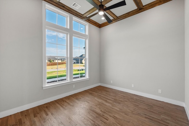 unfurnished room with beam ceiling, a healthy amount of sunlight, wood-type flooring, and coffered ceiling