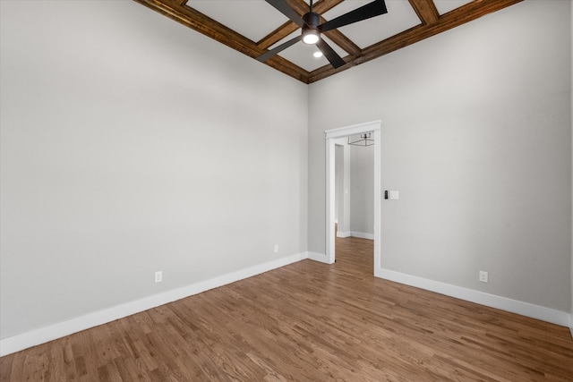 unfurnished room featuring ceiling fan, beam ceiling, coffered ceiling, and wood-type flooring