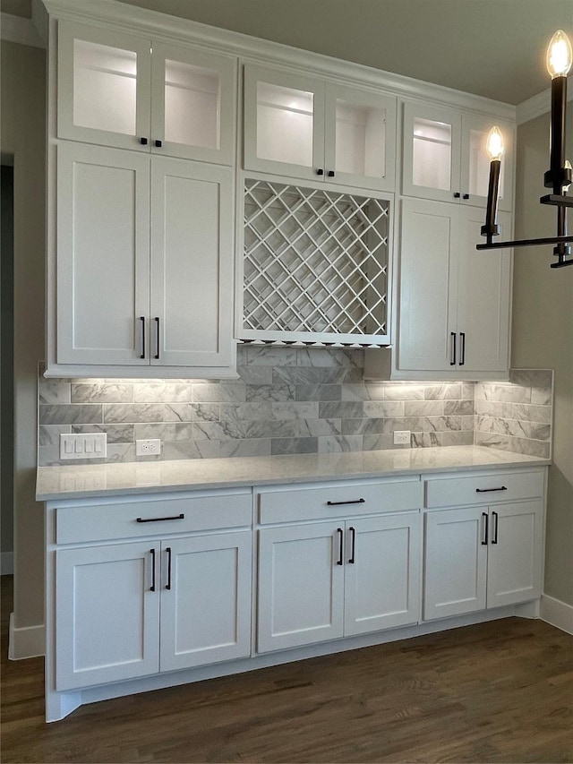 kitchen with dark wood-type flooring, white cabinets, and backsplash