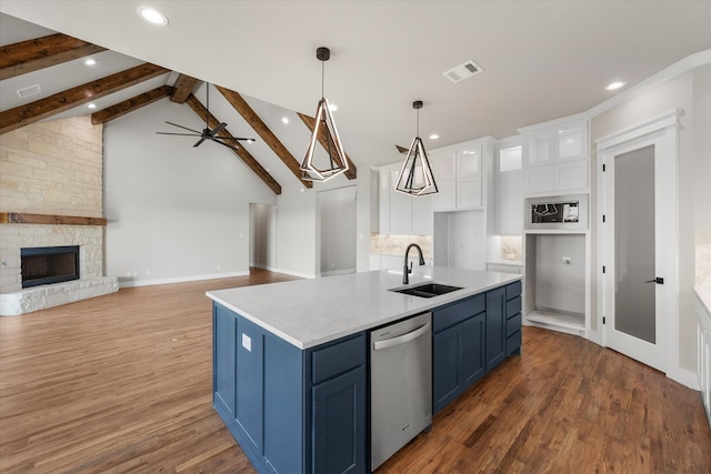 kitchen with dishwasher, hardwood / wood-style floors, white cabinetry, sink, and a fireplace