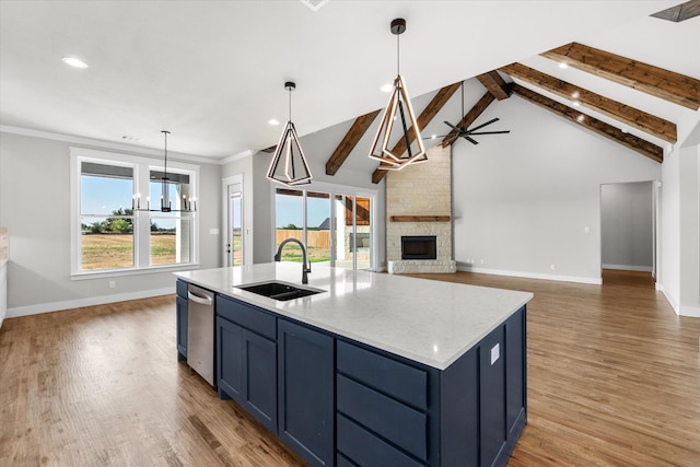 kitchen featuring sink, a stone fireplace, wood-type flooring, brick wall, and pendant lighting