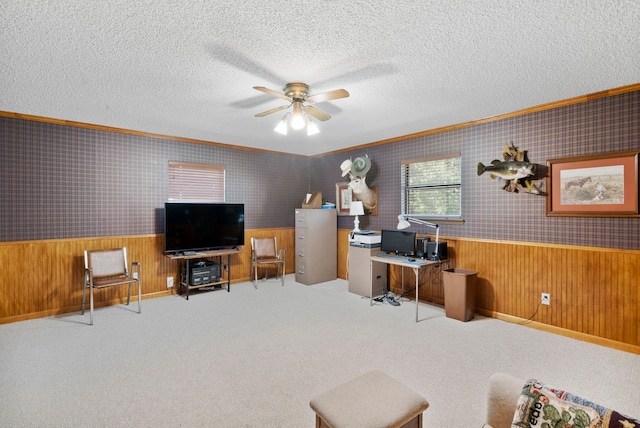 carpeted office space with ceiling fan, a textured ceiling, and wooden walls