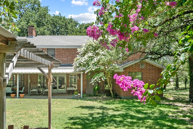 rear view of property with a patio, a lawn, and a pergola