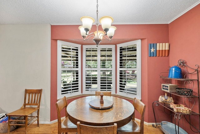 dining room featuring a notable chandelier, a textured ceiling, wood-type flooring, and crown molding