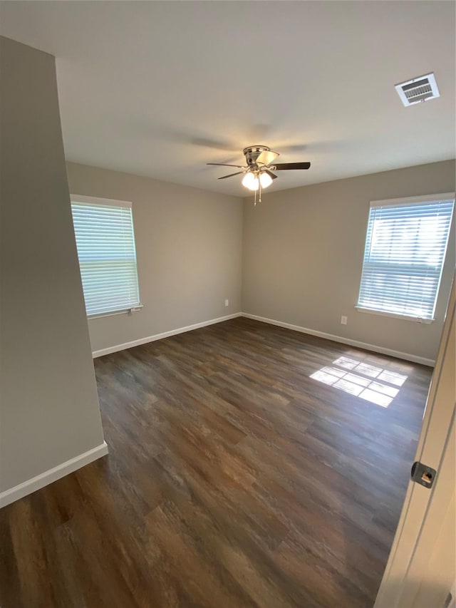 spare room with dark hardwood / wood-style flooring and ceiling fan