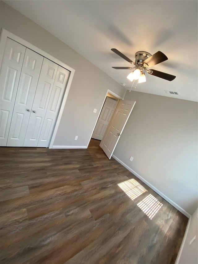 unfurnished bedroom featuring dark hardwood / wood-style flooring, a closet, and ceiling fan