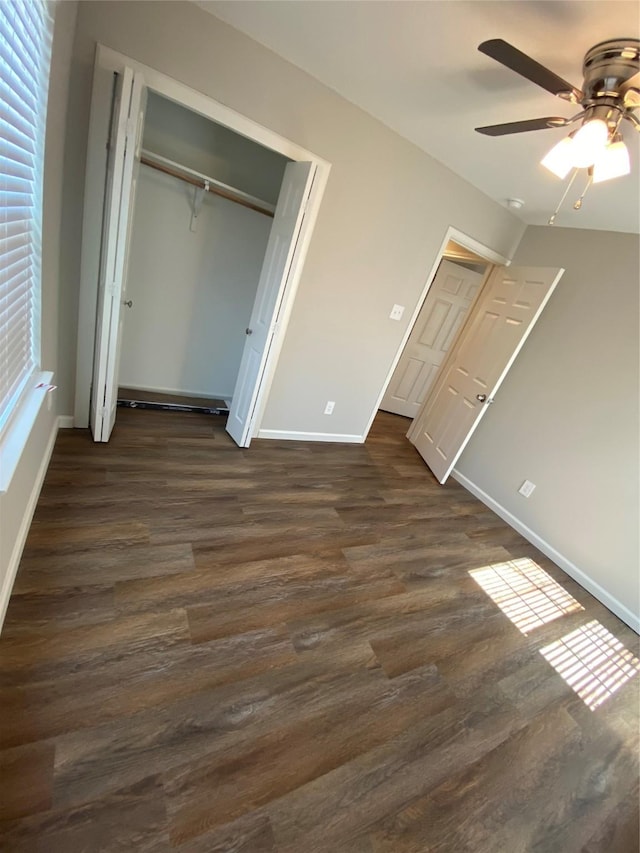 unfurnished bedroom with ceiling fan, a closet, and dark wood-type flooring