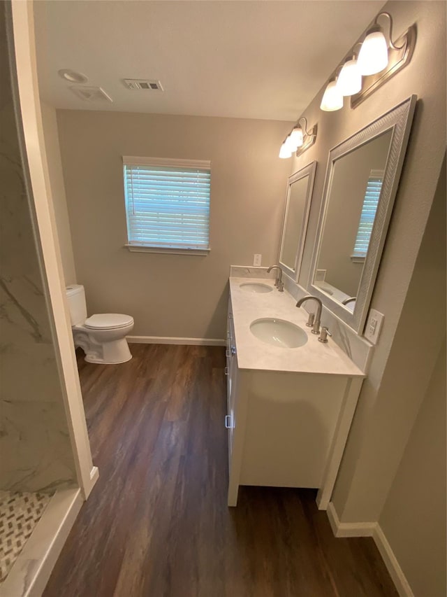 bathroom featuring walk in shower, vanity, wood-type flooring, and toilet