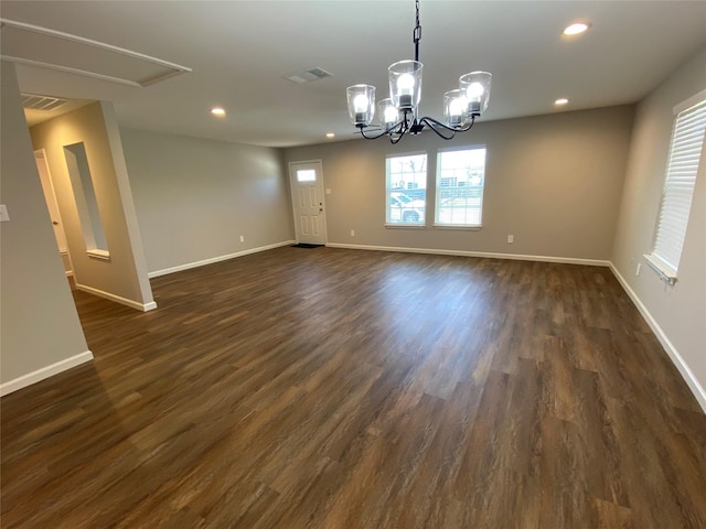 spare room with a chandelier and dark hardwood / wood-style floors