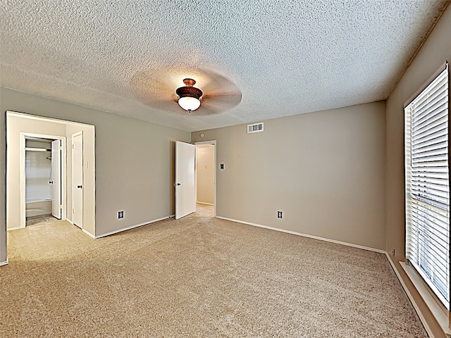 carpeted empty room with a textured ceiling and ceiling fan