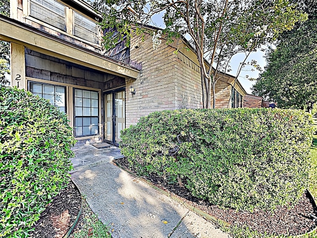 entrance to property featuring brick siding