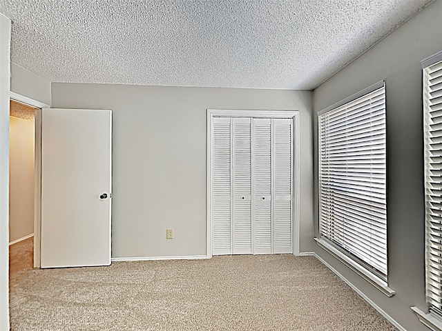 unfurnished bedroom featuring a closet, carpet flooring, and a textured ceiling