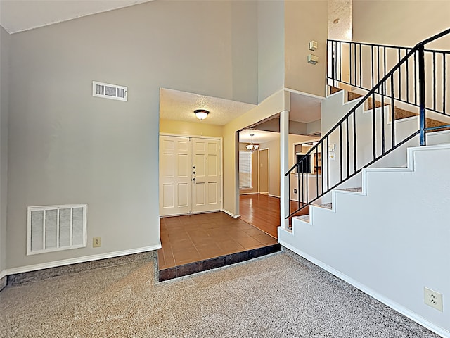 entryway with carpet floors and a high ceiling