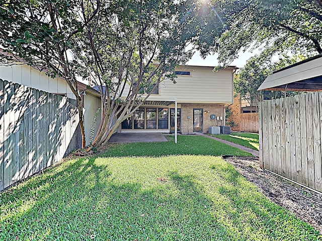 back of house featuring a patio, a fenced backyard, a yard, central air condition unit, and brick siding