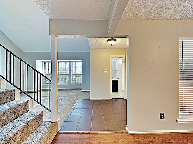 tiled entryway featuring a textured ceiling