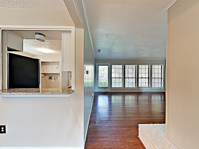 hall with dark hardwood / wood-style floors and a textured ceiling