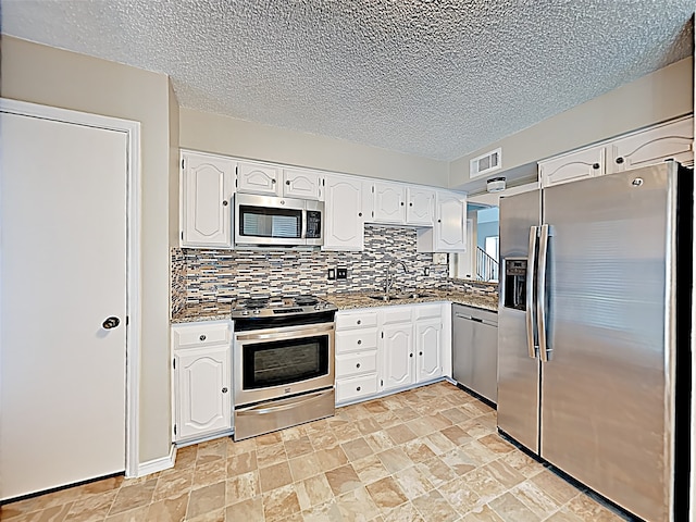 kitchen featuring white cabinetry, light tile patterned floors, backsplash, stainless steel appliances, and stone counters