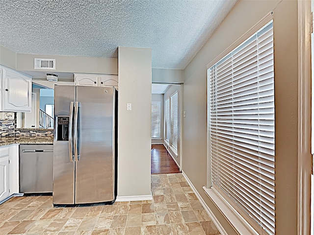 kitchen featuring light tile patterned flooring, appliances with stainless steel finishes, and white cabinets