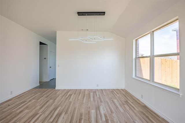 unfurnished room with vaulted ceiling and light hardwood / wood-style floors