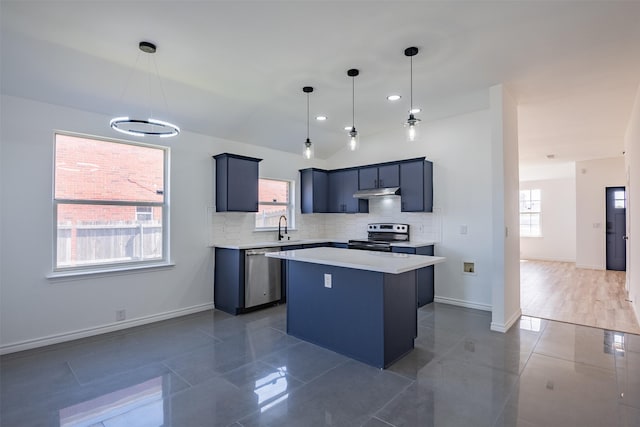 kitchen featuring stainless steel appliances, backsplash, a center island, decorative light fixtures, and sink