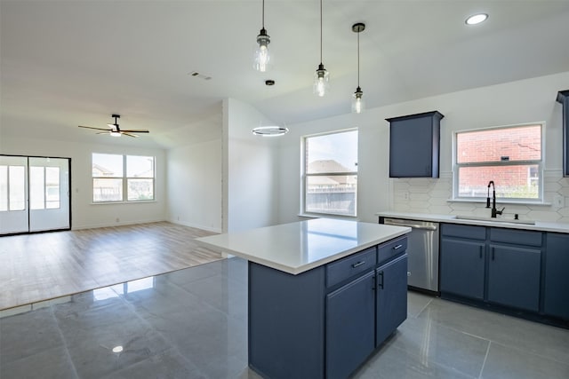 kitchen featuring ceiling fan, backsplash, a center island, stainless steel dishwasher, and sink