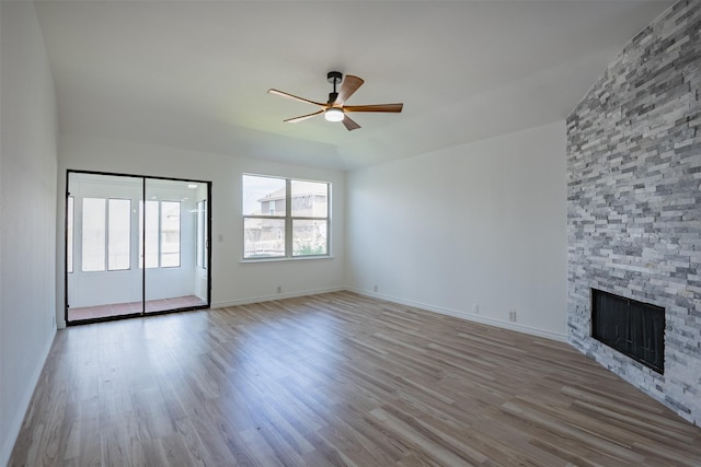 unfurnished living room featuring ceiling fan, light wood-type flooring, and a fireplace