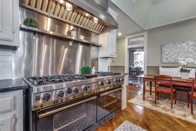 kitchen with ventilation hood, double oven range, white cabinets, and dark hardwood / wood-style floors