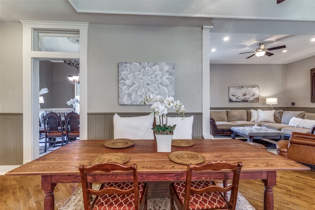 dining area with ceiling fan with notable chandelier and wood-type flooring