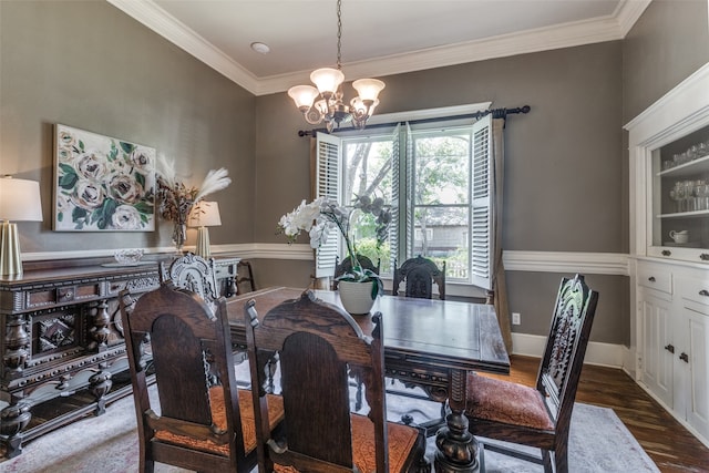 dining room featuring dark wood-type flooring, an inviting chandelier, and ornamental molding