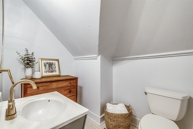 bathroom featuring vaulted ceiling, toilet, and vanity