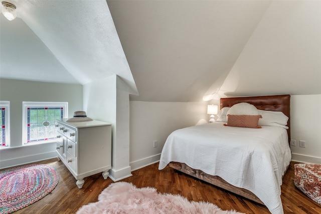 bedroom with lofted ceiling and dark hardwood / wood-style floors