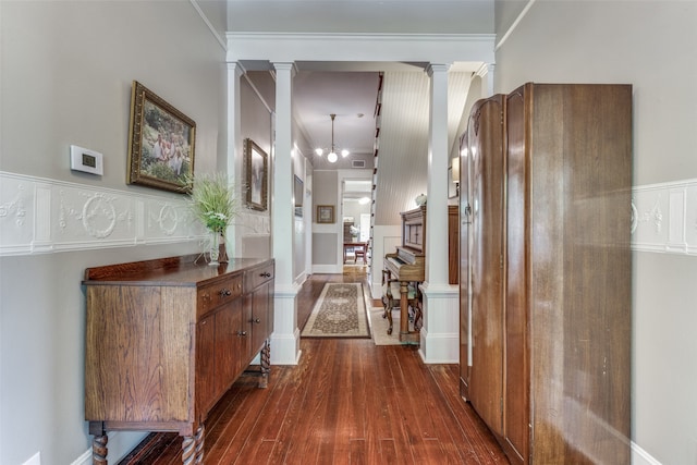 hall with decorative columns and dark hardwood / wood-style floors