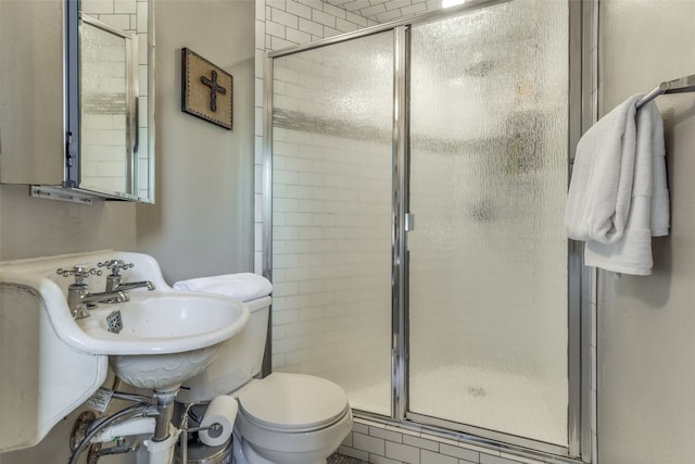 bathroom featuring toilet and a shower with shower door