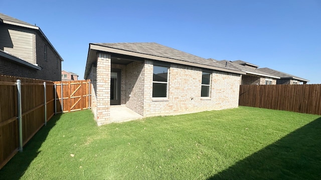 rear view of property featuring a yard