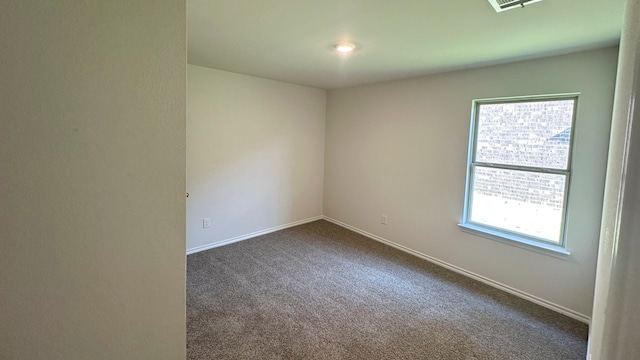 unfurnished room featuring dark colored carpet