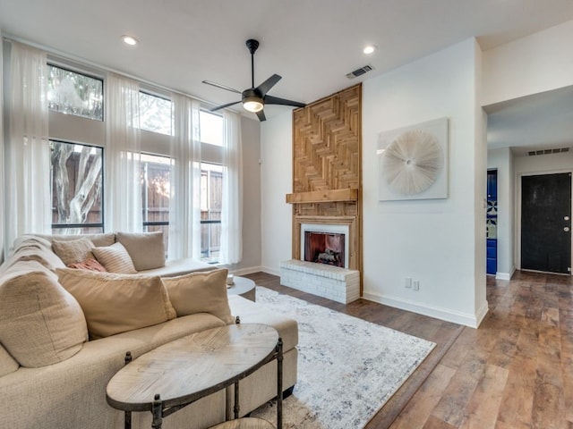 living room featuring a fireplace, hardwood / wood-style flooring, and ceiling fan