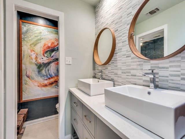 bathroom with tile patterned flooring, decorative backsplash, toilet, and vanity