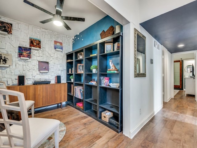 sitting room with ceiling fan and hardwood / wood-style floors