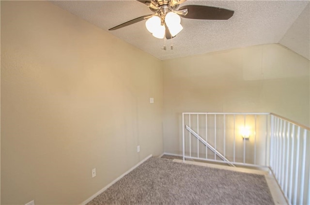 spare room featuring carpet flooring, a textured ceiling, vaulted ceiling, and ceiling fan