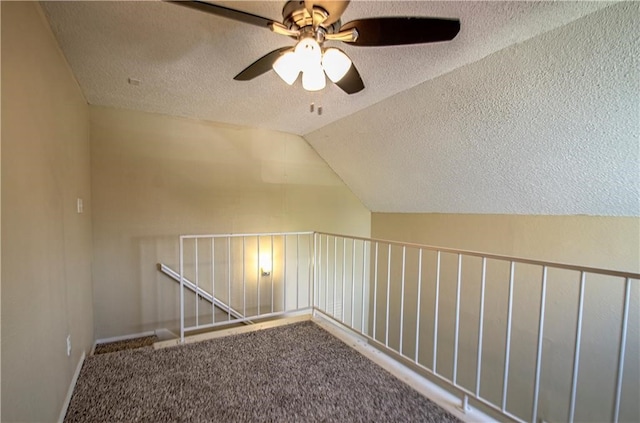 interior space featuring vaulted ceiling, carpet floors, and a textured ceiling